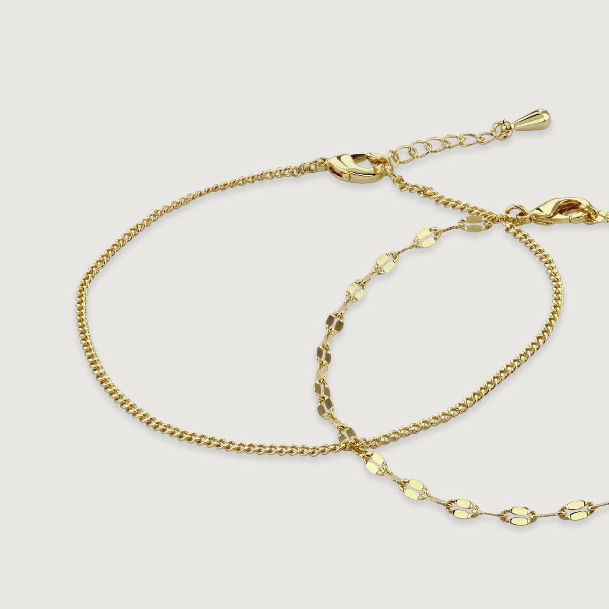 Discover the perfect balance of elegance and simplicity with this Set of Two Gold Chain Bracelets. One showcases a chic flat double chain, adding a contemporary edge, while the other showcases a classic and understated plain chain. Wear them individually 