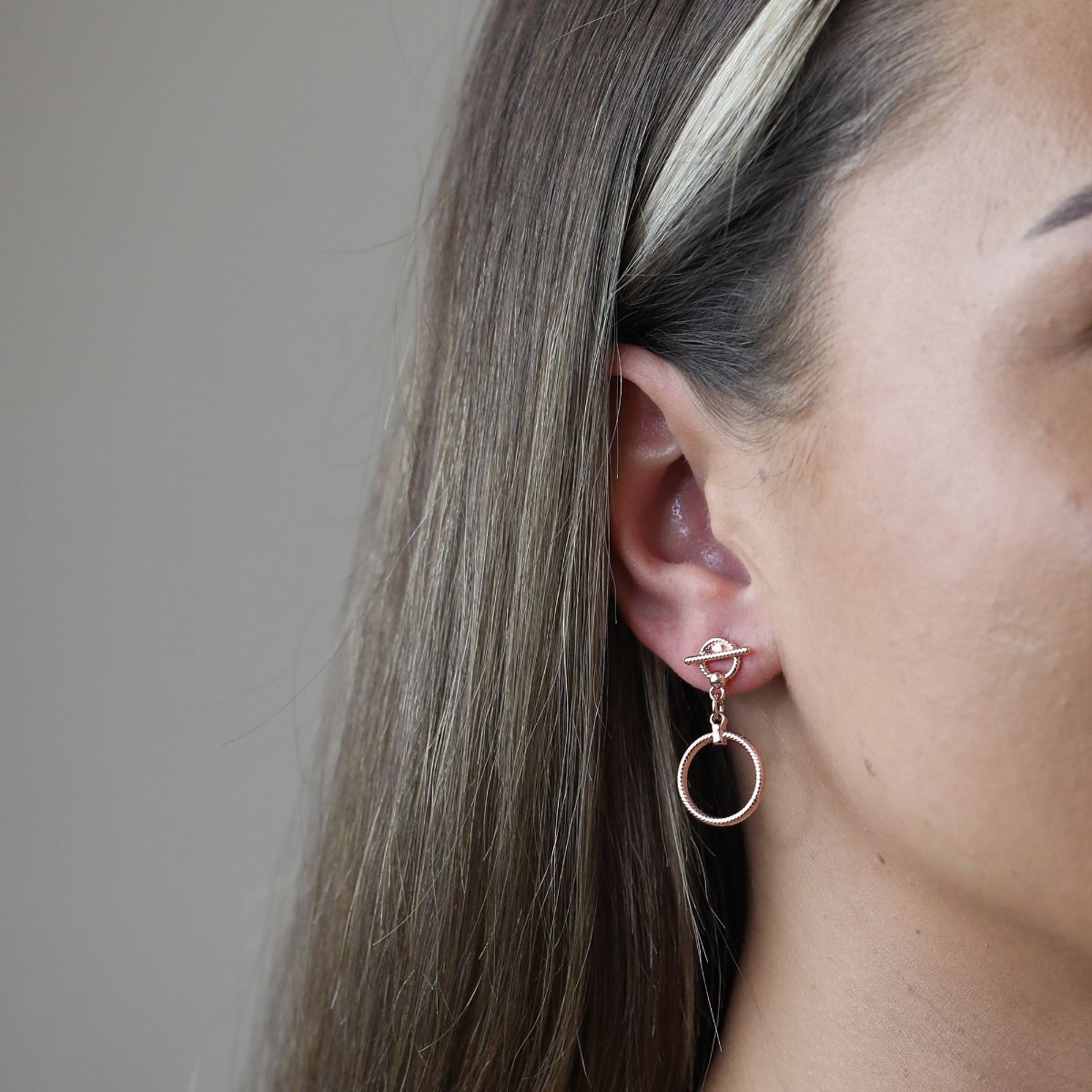 The Rose Gold Rope Style T-Bar Earrings are elegant and captivating. Crafted with meticulous attention to detail, these earrings feature a delicate rope-style design in a beautiful rose gold hue. The T-Bar pendant adds a touch of sophistication, making th