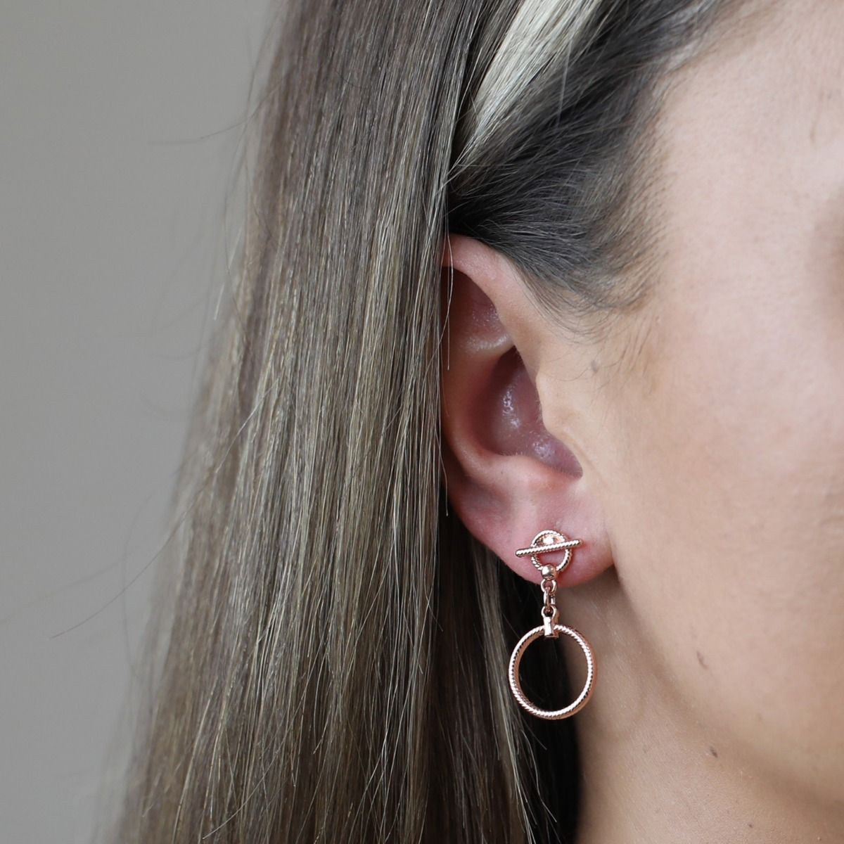 The Rose Gold Rope Style T-Bar Earrings are elegant and captivating. Crafted with meticulous attention to detail, these earrings feature a delicate rope-style design in a beautiful rose gold hue. The T-Bar pendant adds a touch of sophistication, making th