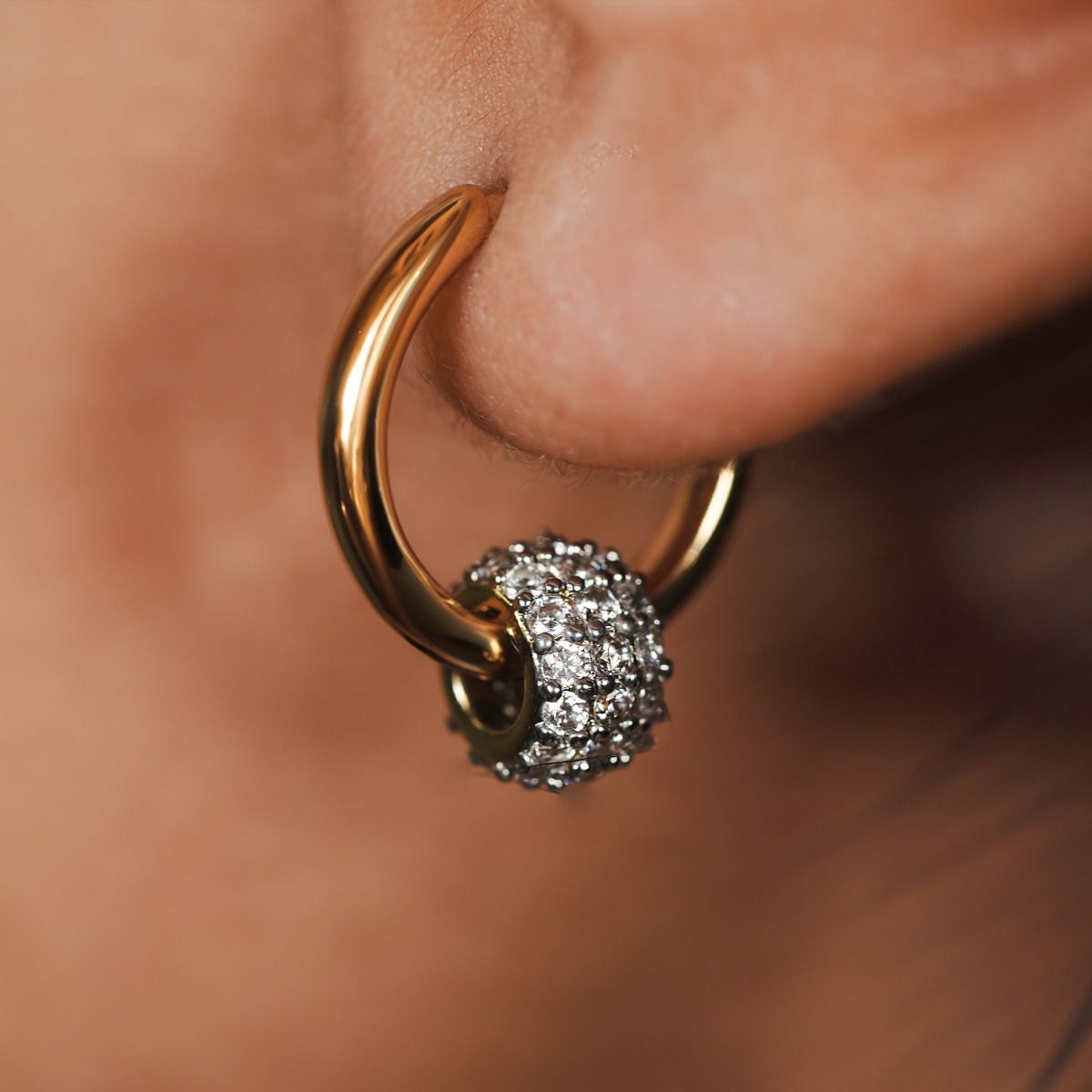 Elevate your style with our Two-Tone Pave Barrel Hoop Earrings. These exquisite earrings combine a polished gold hoop with a cubic zirconia encrusted barrel. Perfect for adding a touch of sophistication and eye-catching detail to any outfit. 