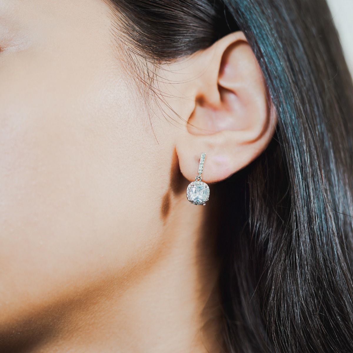 These striking stud drop earrings are set with flawlessly cut cubic zirconia stones, surrounding a dazzling clear cushion cut centre stone. Wear to add timeless glamour to any look.