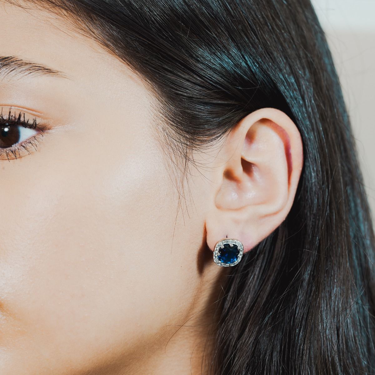 These striking stud drop earrings are set with flawlessly cut cubic zirconia stones, surrounding a dazzling Sapphire coloured cushion cut centre stone. Wear to add timeless glamour to any look.