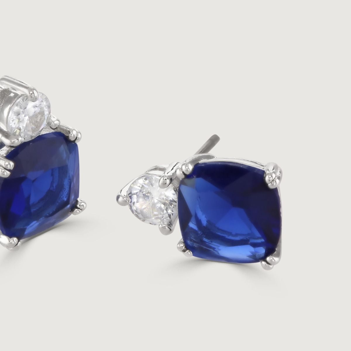 These show stopping stud earrings are set with a flawless brilliant cut cubic zirconia above a striking cushion cut Sapphire coloured stone. Wear to add timeless glamour to any look.