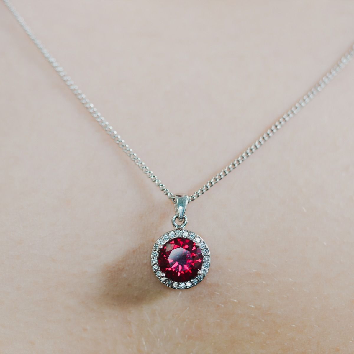 Experience enchantment through our Ruby Halo Pendant. The impressive round-cut centre stone emanates a captivating allure. Effortlessly elevate your style with this exquisite piece, infusing timeless glamour into any ensemble.