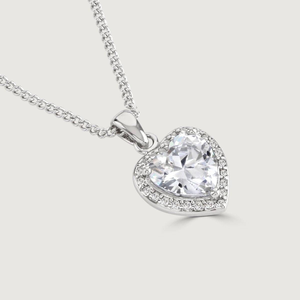 Embrace the allure of romance with our exquisite Clear Heart Pendant. A brilliant cubic zirconia takes centre stage, encircled by a mesmerising array of sparkling companions. 