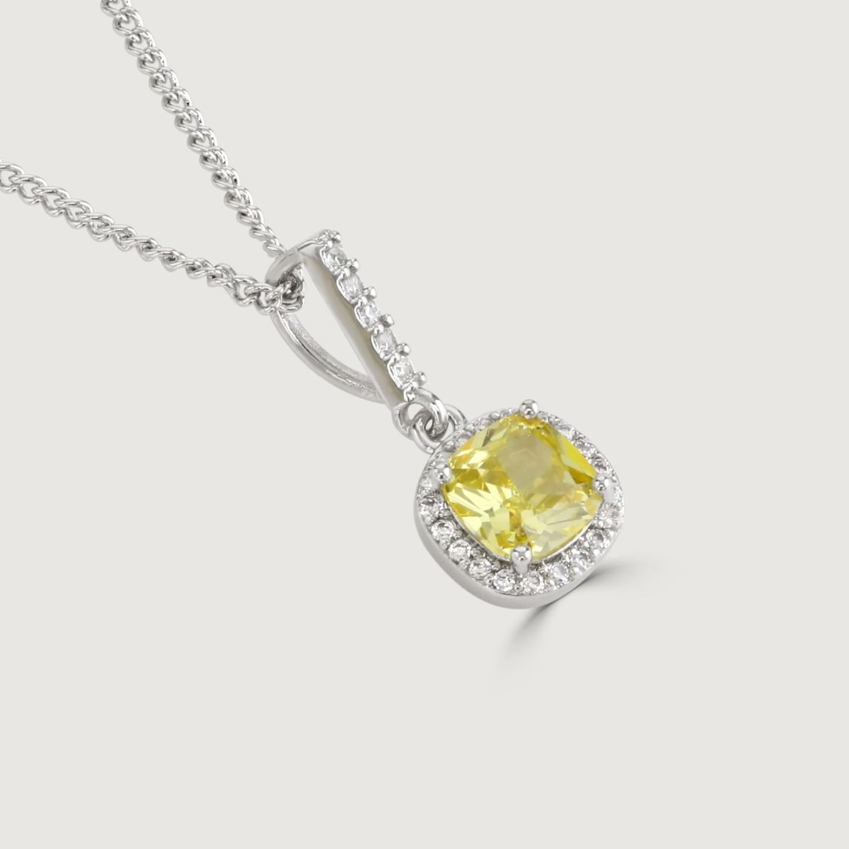 The Canary Cushion Drop Pendant is a enrapturing piece. Impeccably shaped cubic zirconia stones encircle a yellow diamond cushion cut centre, exuding a mesmerising allure.