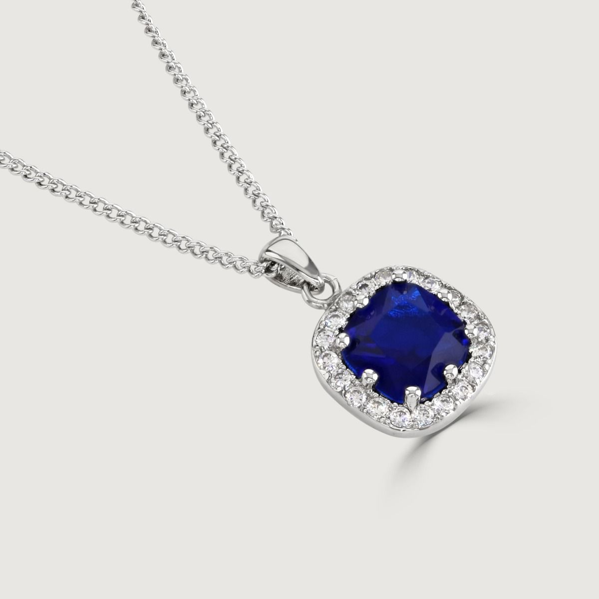 Reveal the allure of our Sapphire Cushion Halo Pendant, adorned with meticulously crafted cubic zirconia stones encircling a radiant clear cushion-cut centre. Elevate your style effortlessly with this timeless piece.
