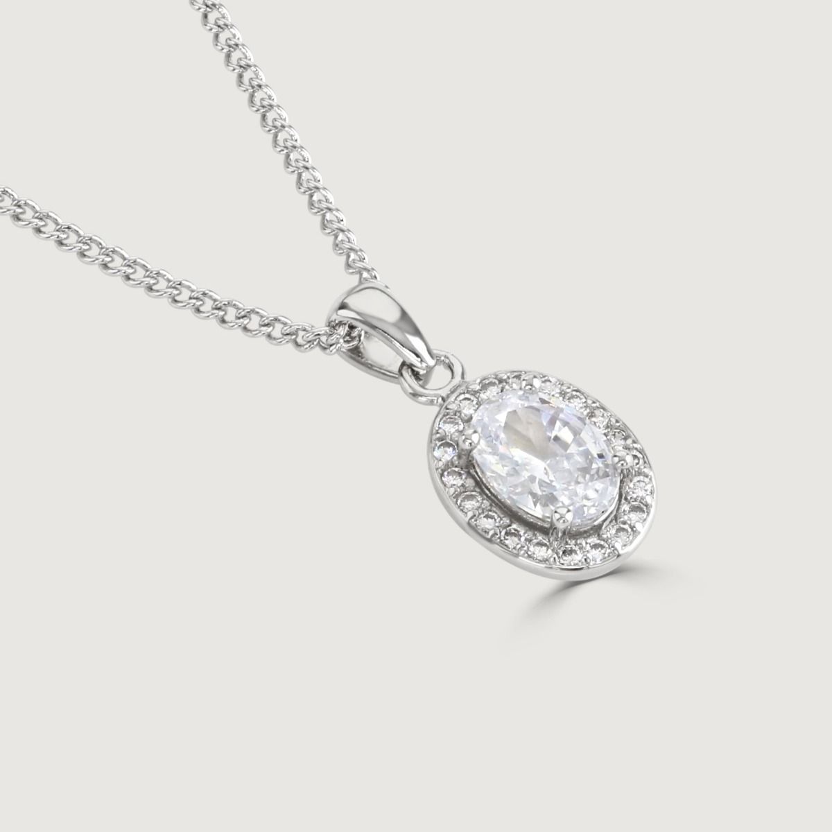 Reveal the allure of our Clear Oval Halo Pendant, adorned with meticulously crafted cubic zirconia stones encircling a radiant clear oval-cut centre.