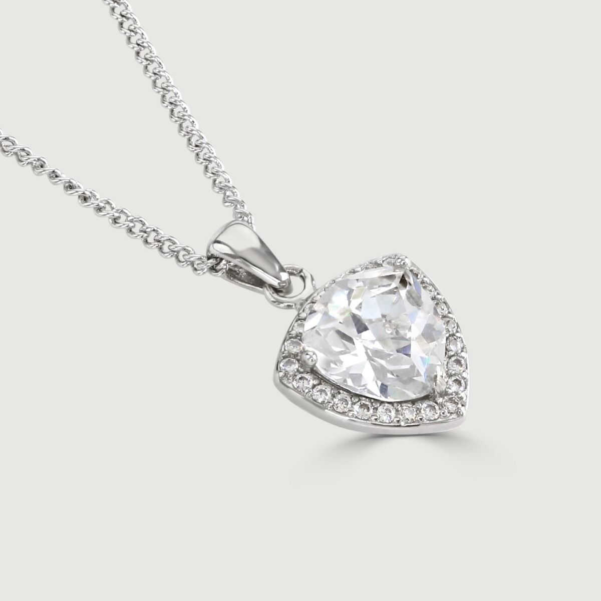 Experience enchantment through our Clear Trillion Halo Pendant. The impressive trillion-cut centre stone emanates a captivating allure. Effortlessly elevate your style with this exquisite piece, infusing timeless glamour into any ensemble.