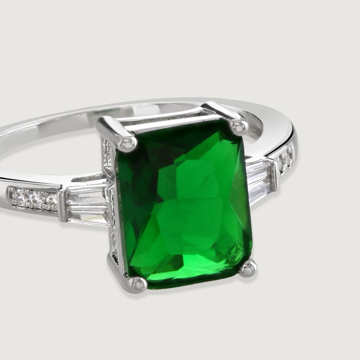 The Emerald Baguette with Tapered Baguette Shoulder Ring is a stunning art deco inspired ring featuring an immaculate baguette cut central glass stone, with tapered stone baguette sides flawlessly faceted for maximum sparkle.