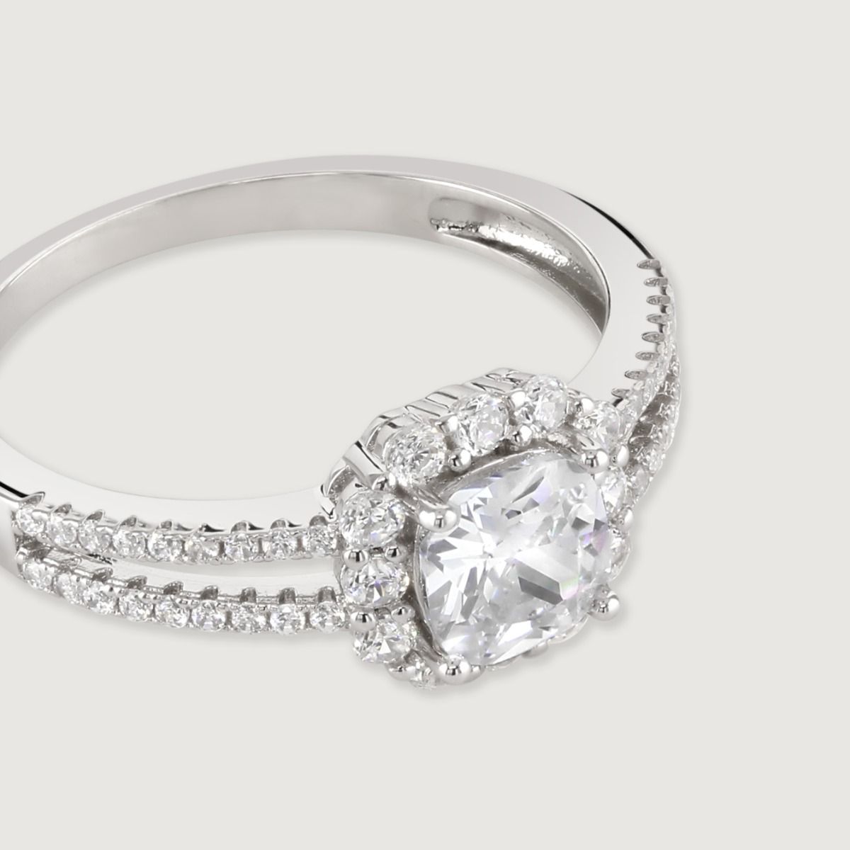 This striking design features a split band adorned with small, dazzling cubic zirconia stones to create a show stopping effect. At the centre lies a cushion cut clear cubic zirconia, multi faceted for maximum sparkle, surrounded with a halo of glittering 