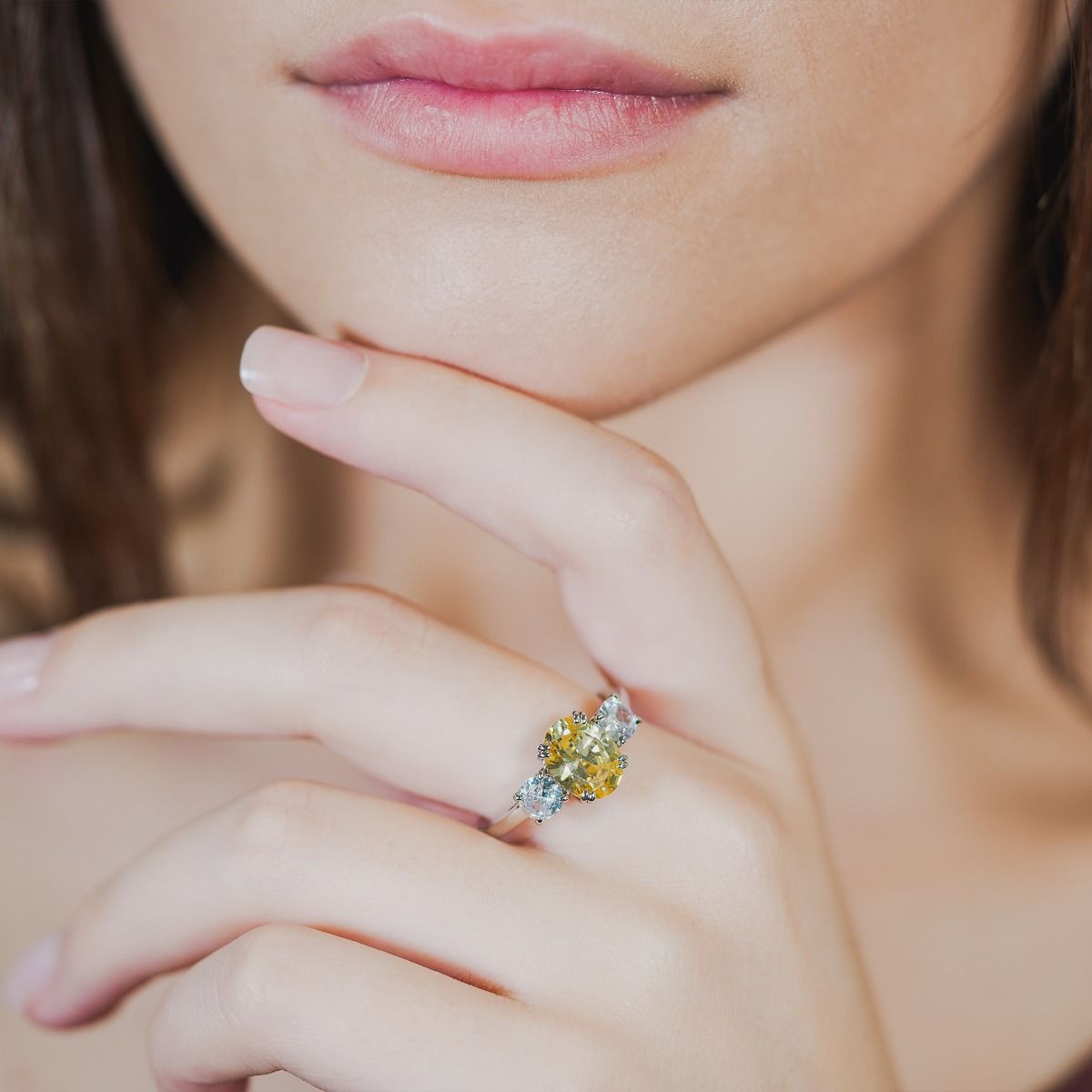 A truly dazzling design, this stunning ring features a canary coloured oval centre stone between two smaller  brilliant cut clear cubic zirconia stones. 