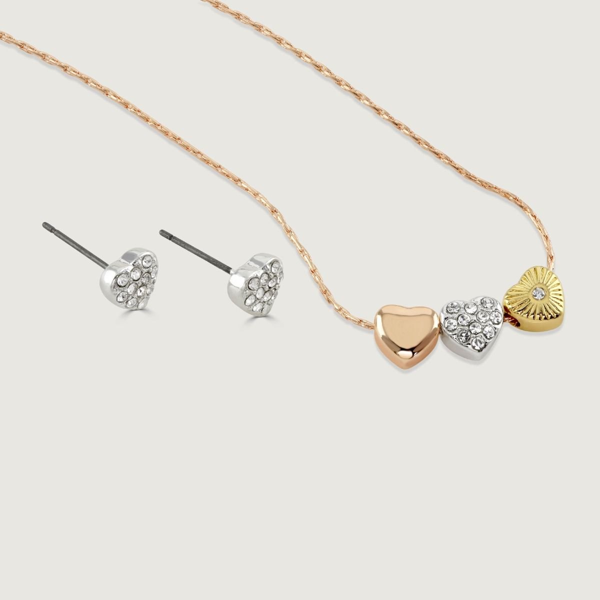 This sweet pendant and earrings set makes the perfect gift for someone special. The pendant features slender rose gold tone chain, decorated with a trio of beautiful heart charms in polished rose gold tone, silver tone with clear crystals, and gold tone w