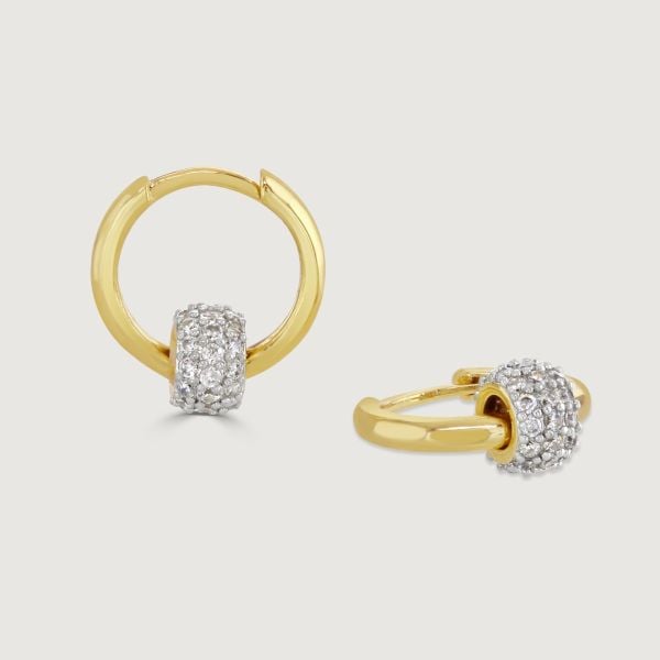 Elevate your style with our Two-Tone Pave Barrel Hoop Earrings. These exquisite earrings combine a polished gold hoop with a cubic zirconia encrusted barrel. Perfect for adding a touch of sophistication and eye-catching detail to any outfit. 