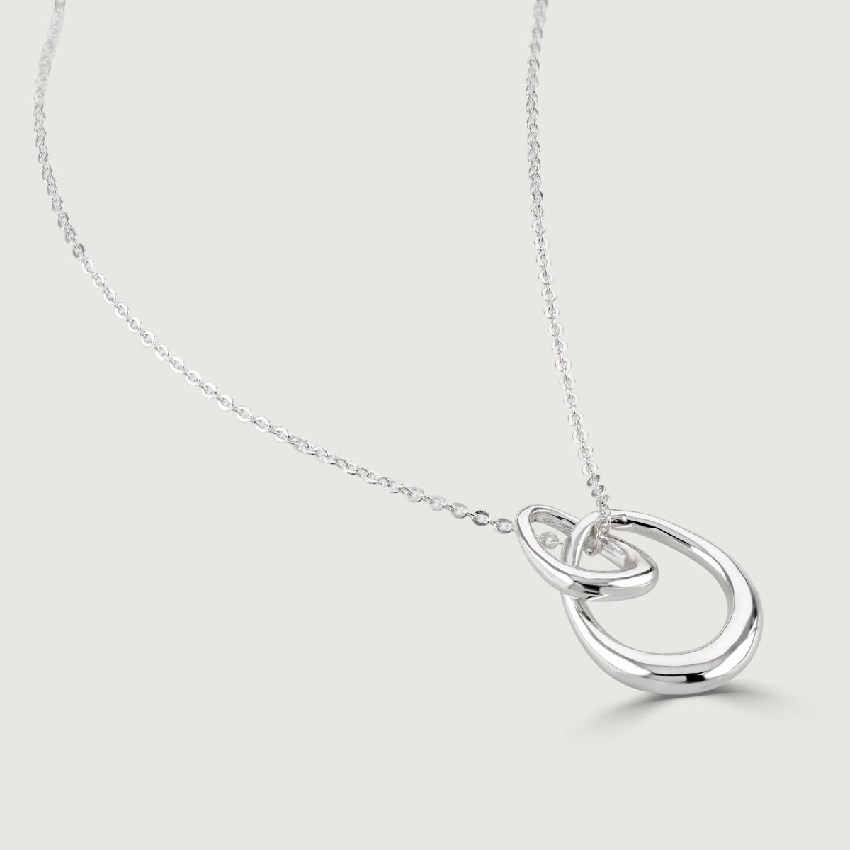 The Silver Organic Double Hoop Pendant is an elegant piece of jewelry crafted with precision. Its intertwining hoops and lustrous silver shine symbolize unity and connection, making it a versatile and sophisticated accessory for any occasion
